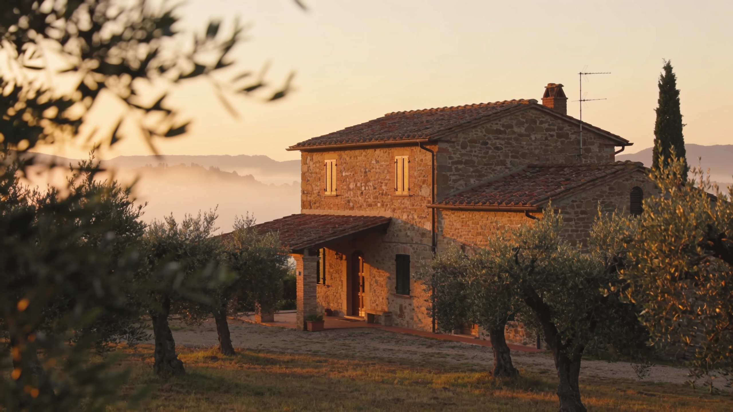 Fazenda de pedra toscana ao amanhecer no campo, rodeada de oliveiras — escolher um alojamento estratégico perto de Saturnia